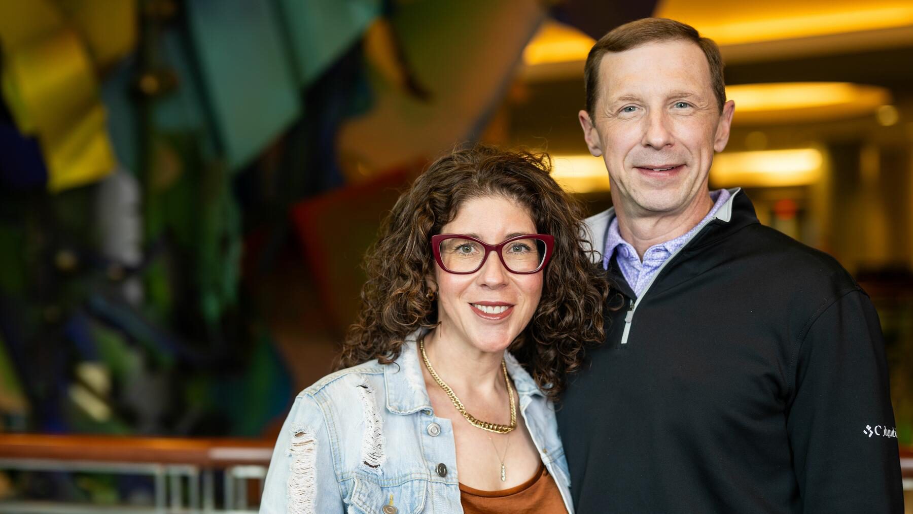 A smiling man and woman stand next to each other