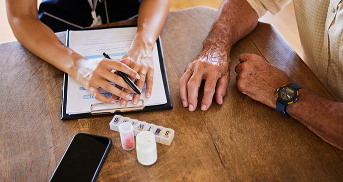 Older man speaking with health care worker
