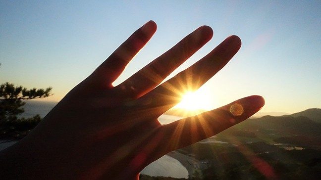 A hand blocking sun rays.