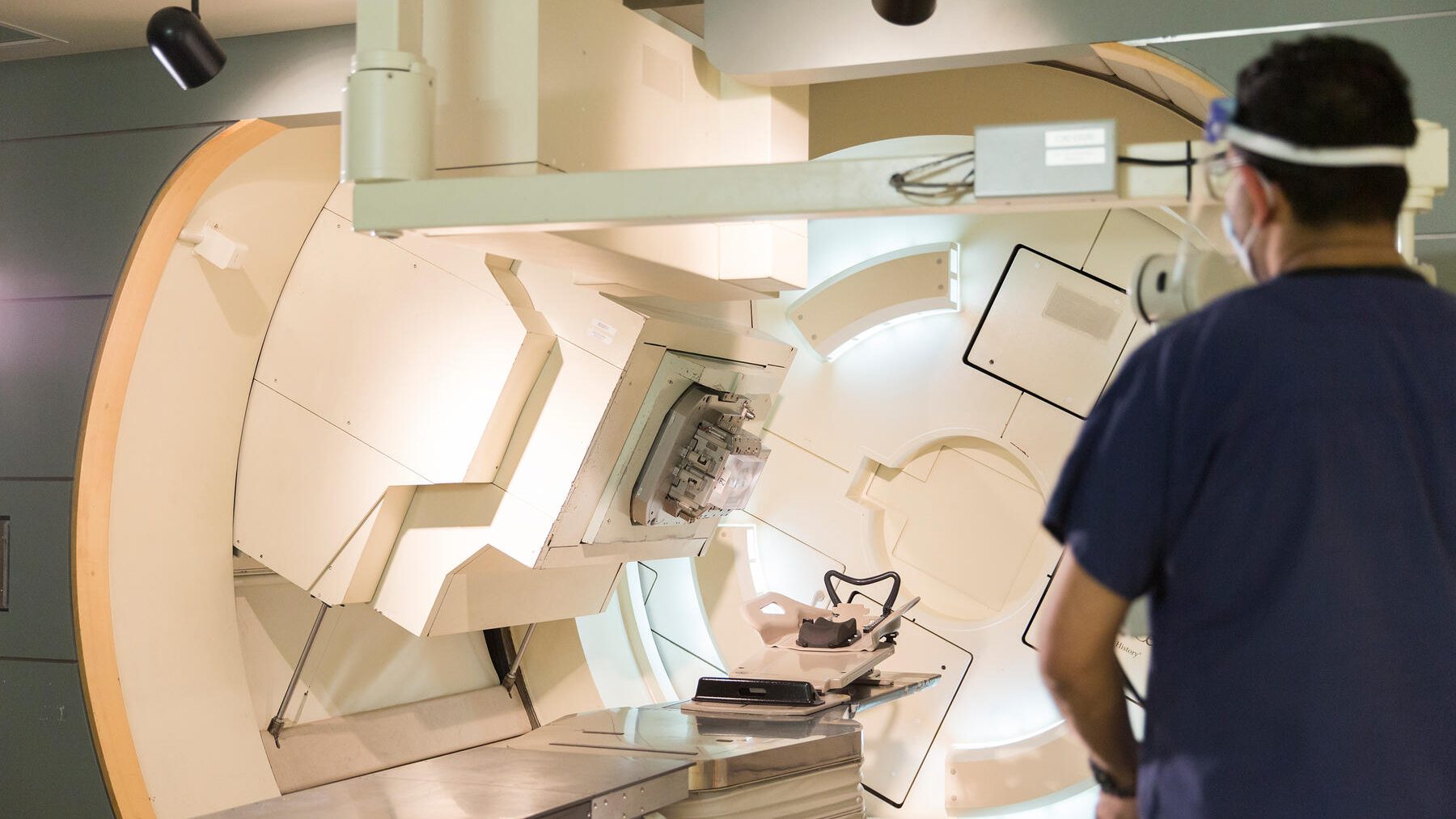 Doctor standing next to a radiation machine