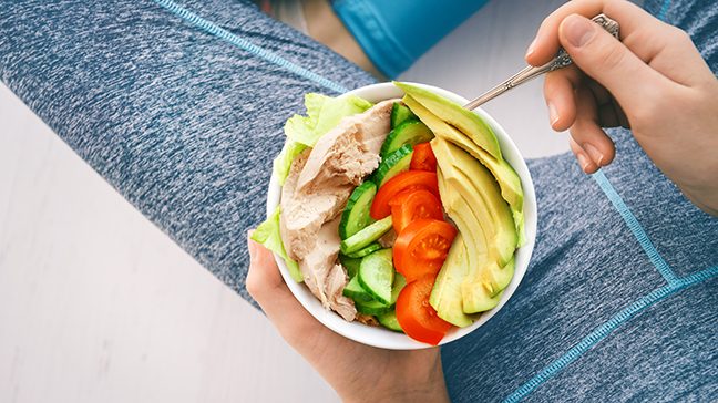 woman eating a healthy DASH diet meal of lean proteins and leafy greens