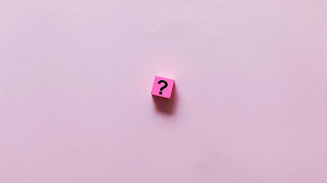 Pink square with a question mark inside of it on a light pink background
