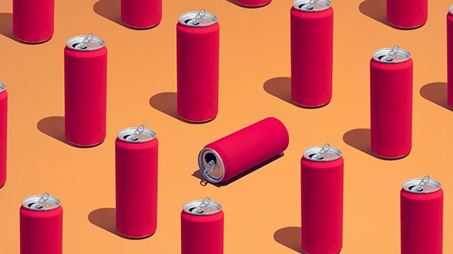 Rows of opened red energy drink cans against an orange background. One can in the middle lies on its side.