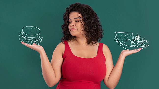 A woman with curly brown hair and a red tank top holds a white illustration of a burger in one hand and a fruit plate in the other.