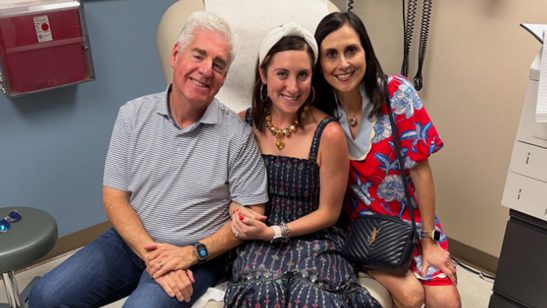 Three adults sit together in a doctor's office