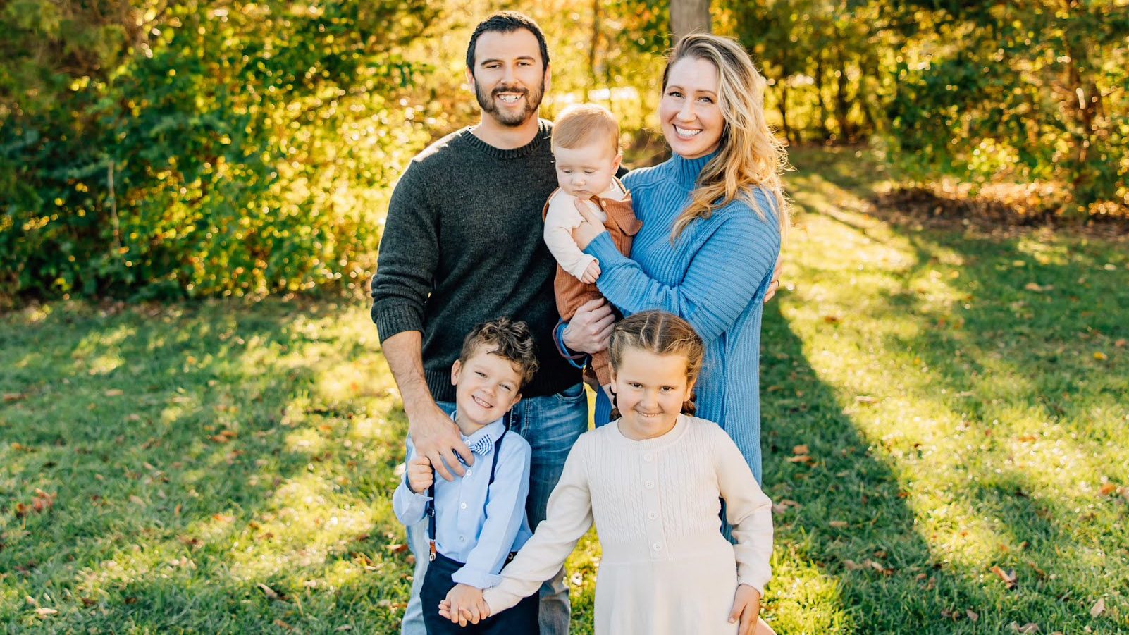 Justin stands with his wife and their three young children
