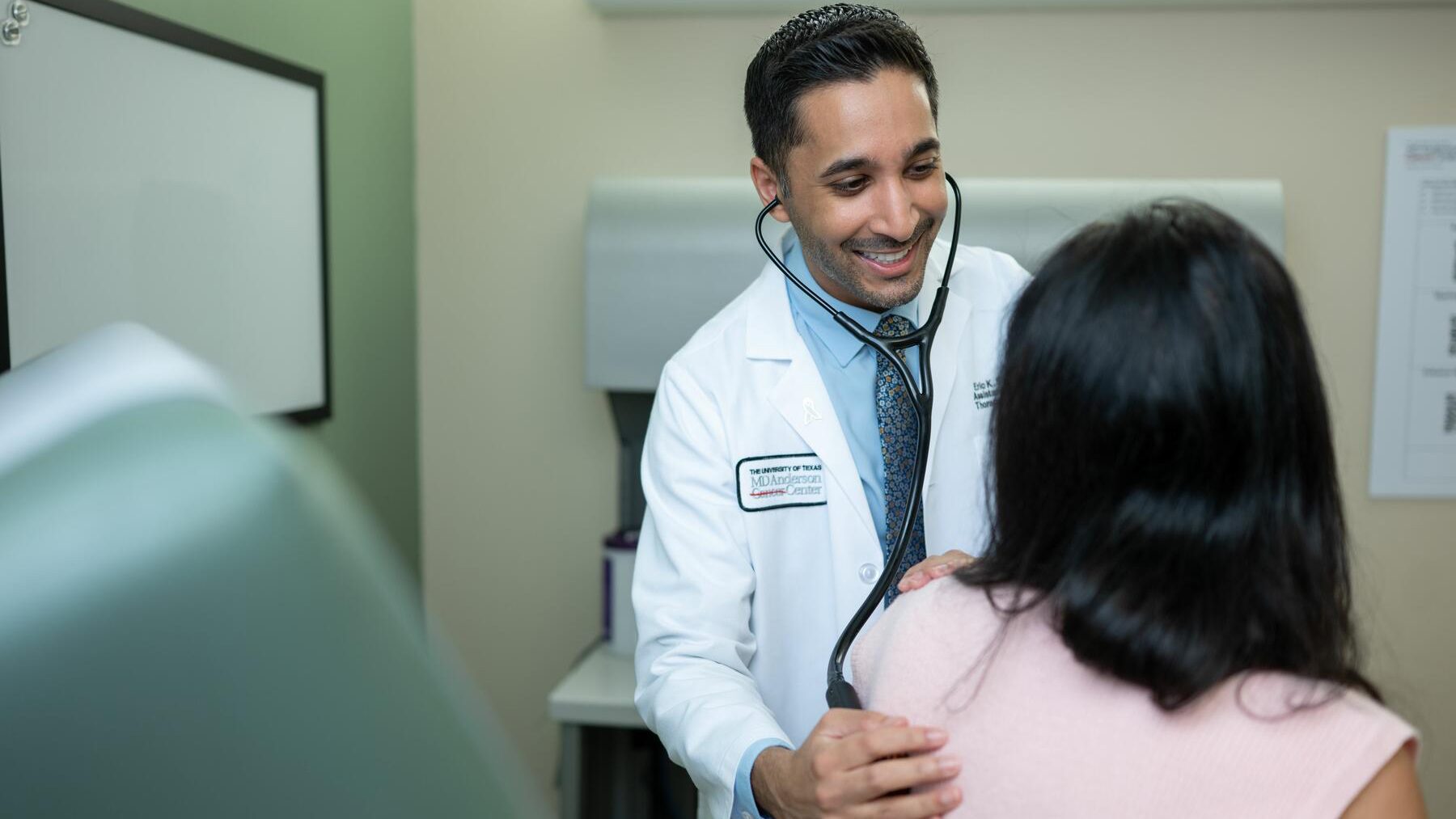 Doctor uses a stethoscope to perform an exam on a female patient