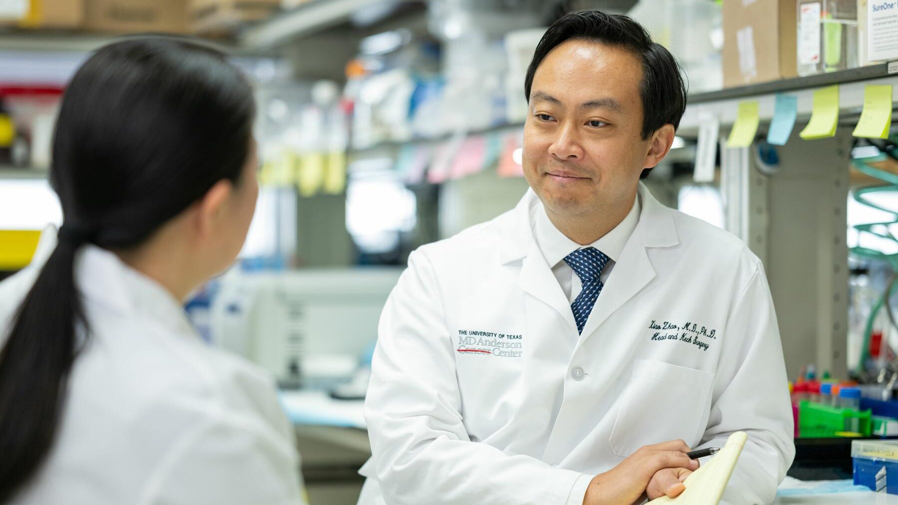 A male and female in a lab wearing physician's coats