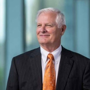 Jim Gallogly - Man in black suit and orange tie.
