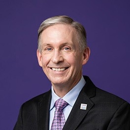 Man in black suit and purple tie.
