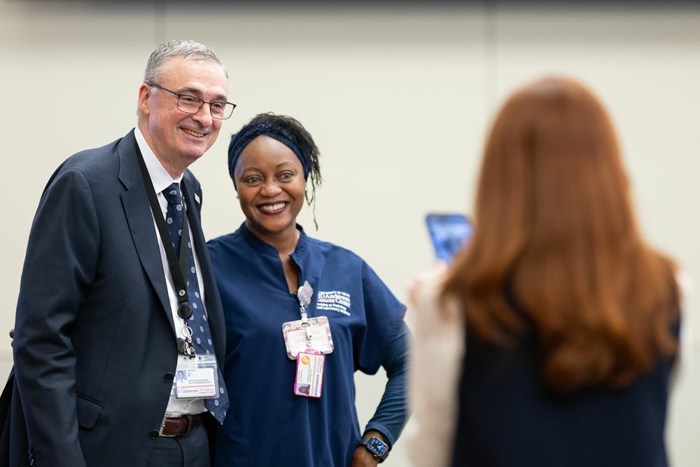 Dr. Lee at the 2026 Fall Service Awards taking a photo with an employee