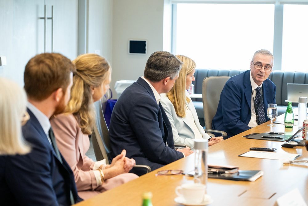 Dr. Lee at a meeting table with guests