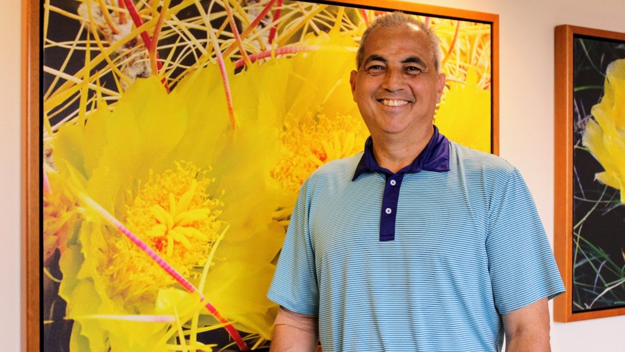 Glioblastoma survivor Tino Gonzalez poses by artwork at MD Anderson