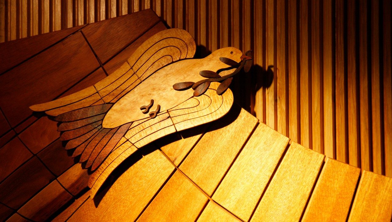 Image of carved decoration in chapel: dove with branch in beak