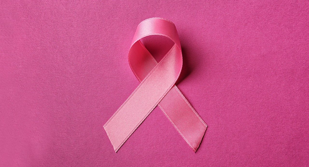 Pink breast cancer ribbon against pink background