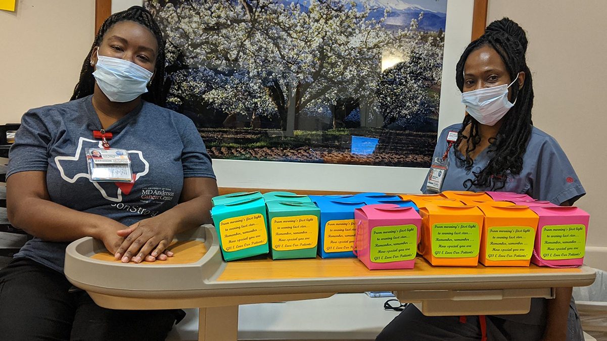 Patient care technician Tequicha Price (right) and patient services coordinator Ashley Stacey stand beside the inspiration boxes they made for patients.