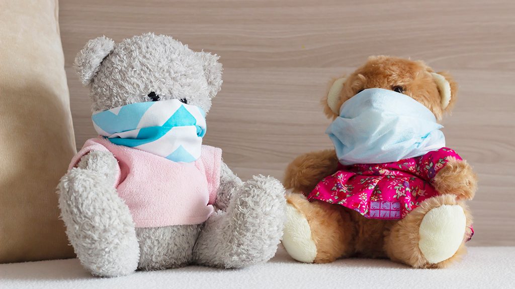 Two teddy bears wearing face masks