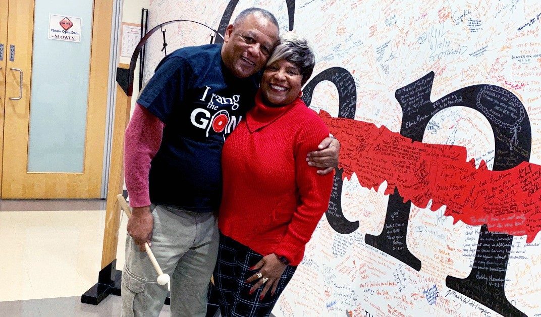 Gregg Davis and his fiancée, Diane Williams, stand by the gong at MD Anderson Proton Therapy Center after he completed proton therapy on Jan. 20, 2020.