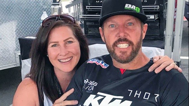 Motorcycle champion Destry Abbott poses with his wife, Charlotte. Both are smiling with arms around each other.