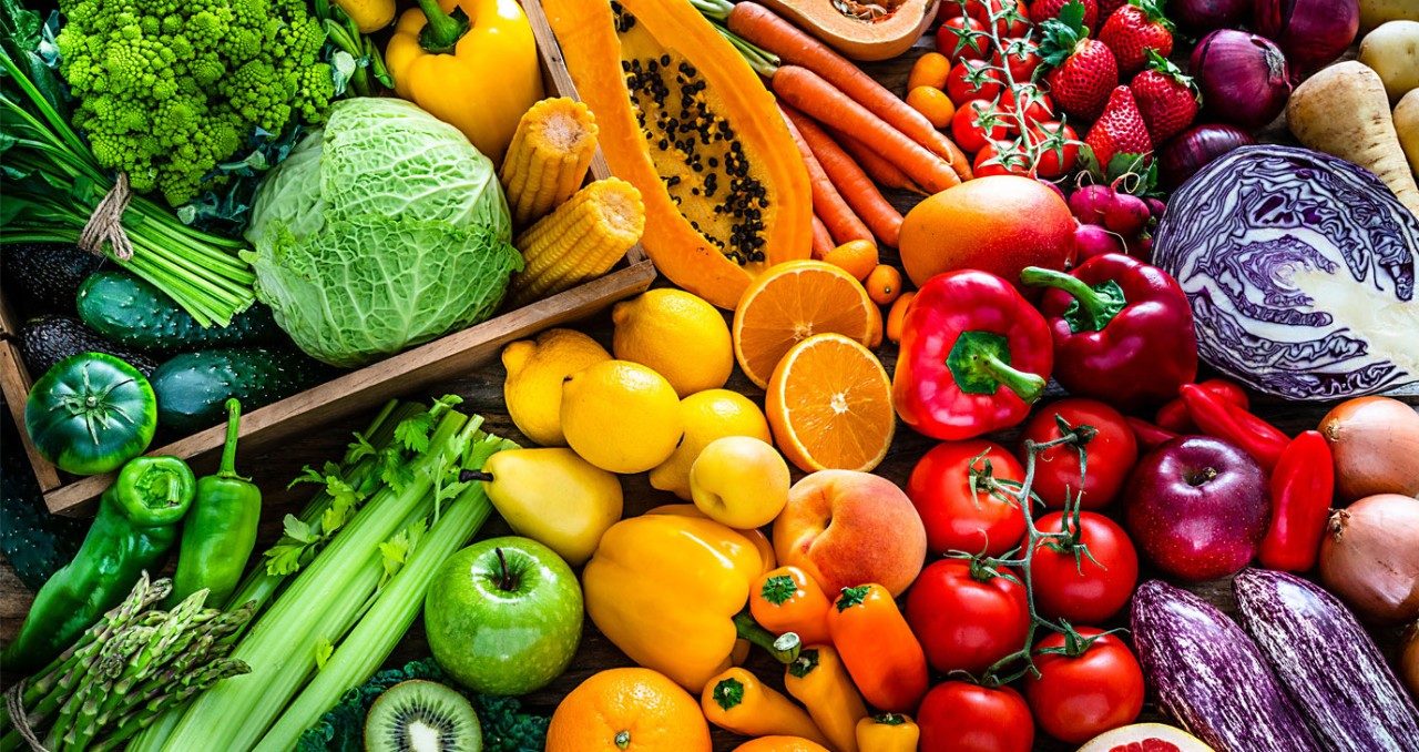 Brightly colored fruit and vegetables are laid out in the colors of the rainbow