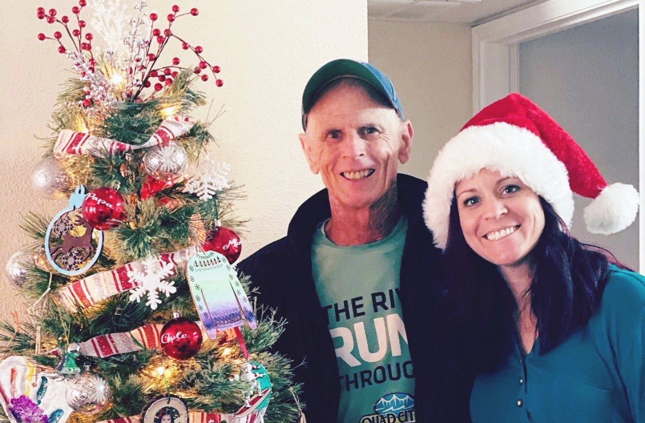 John Sullivan stands beside a Christmas tree with his youngest daughter, Leslie
