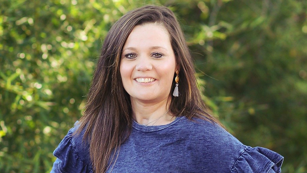 Oral cancer survivor Jessica King poses in front of a tree