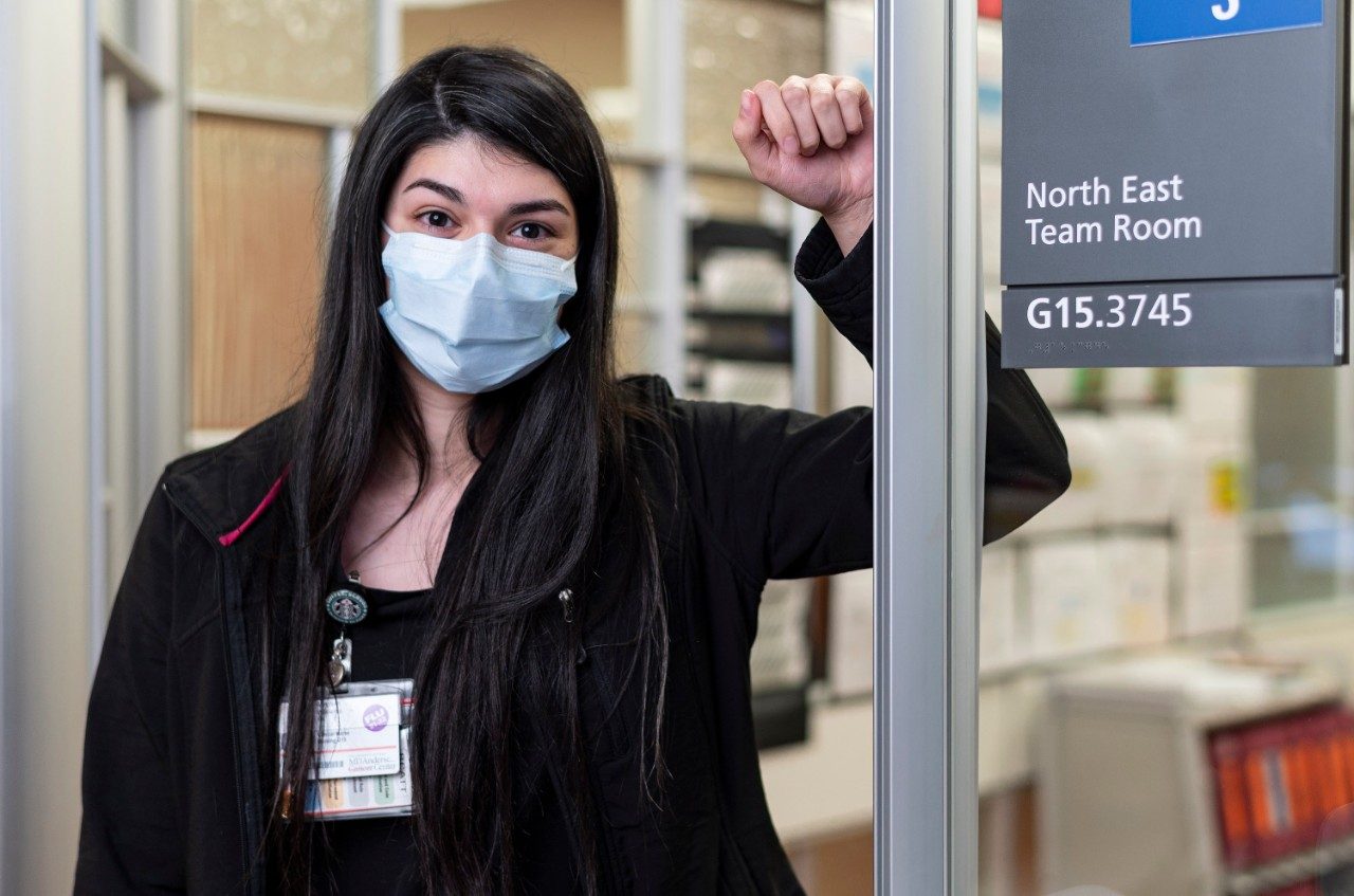 Nurse Meghan Williams stands in front of a door with a sign that says "G15" at MD Anderson Cancer Center