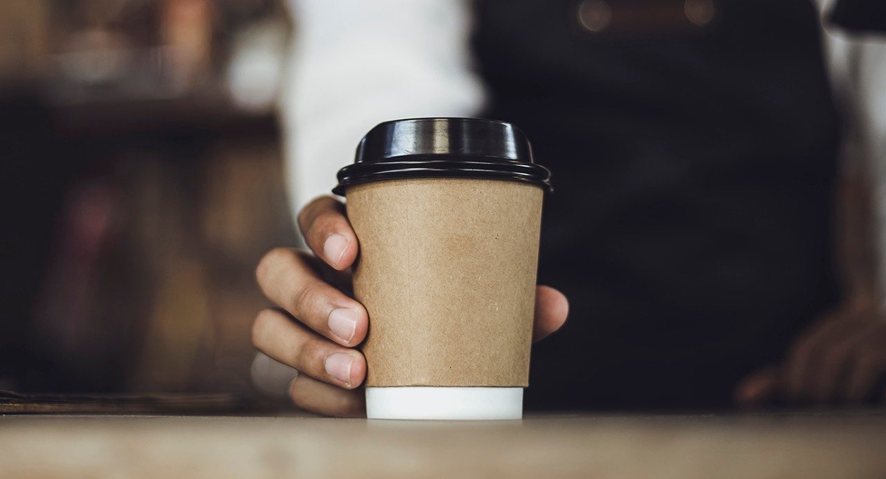 A person holding a cup of coffee.