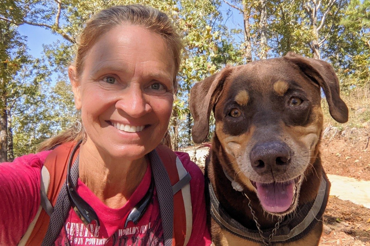 Gail Walsh and her dog posing for a photo on a bike trail
