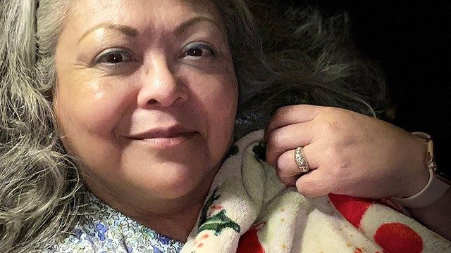 Thymoma survivor Cynthia Sanchez with her poinsettia throw