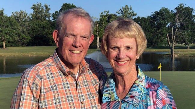 Jim and Carolyn Drone smiling and standing shoulder-to-shoulder on golf course