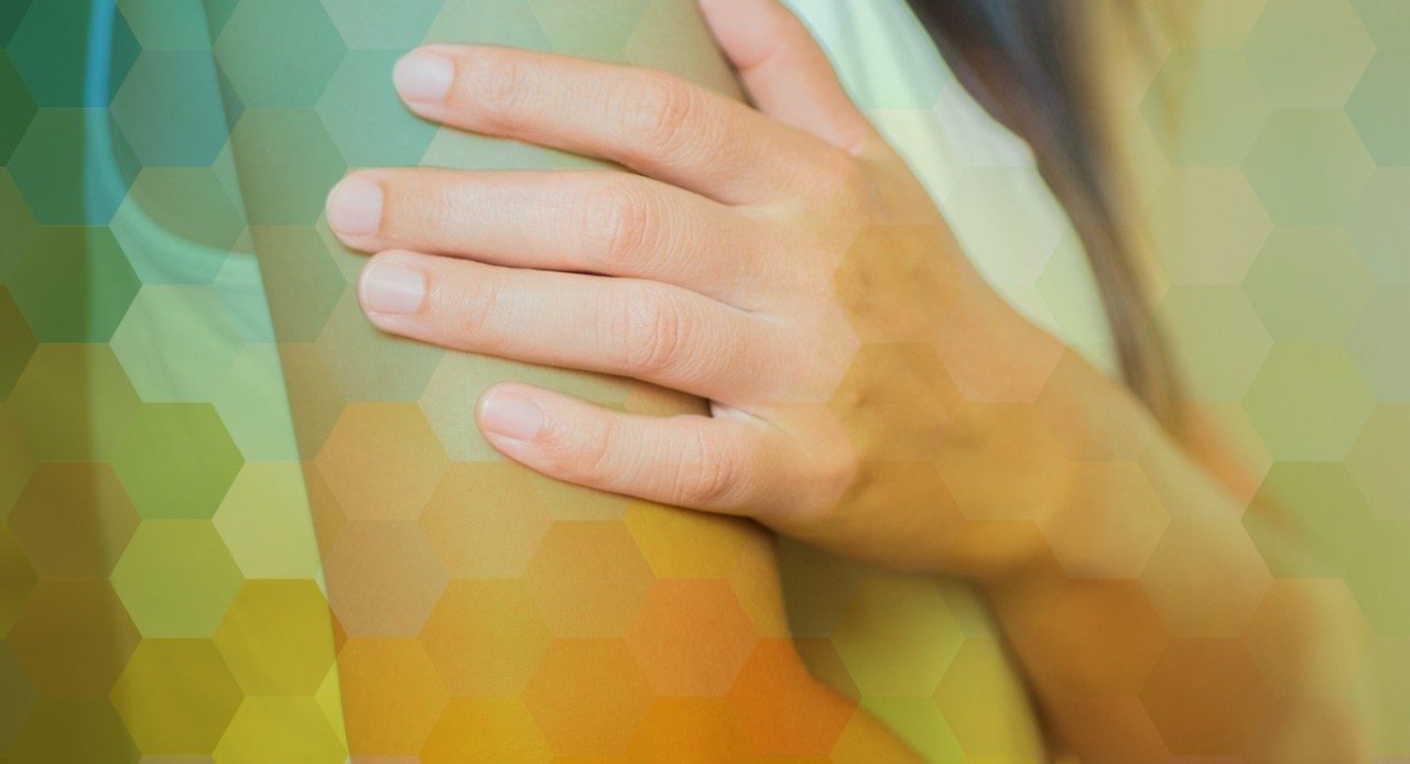 Hand touching an arm with a graphic overlay of a pattern of interlocking pentagons to portray a rash