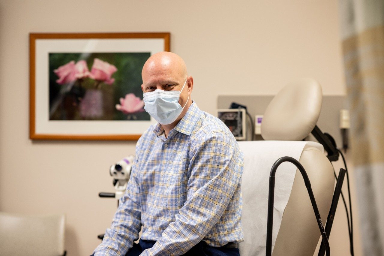 Michael Frumovitz, M.D., sits in a clinic room as a patient.