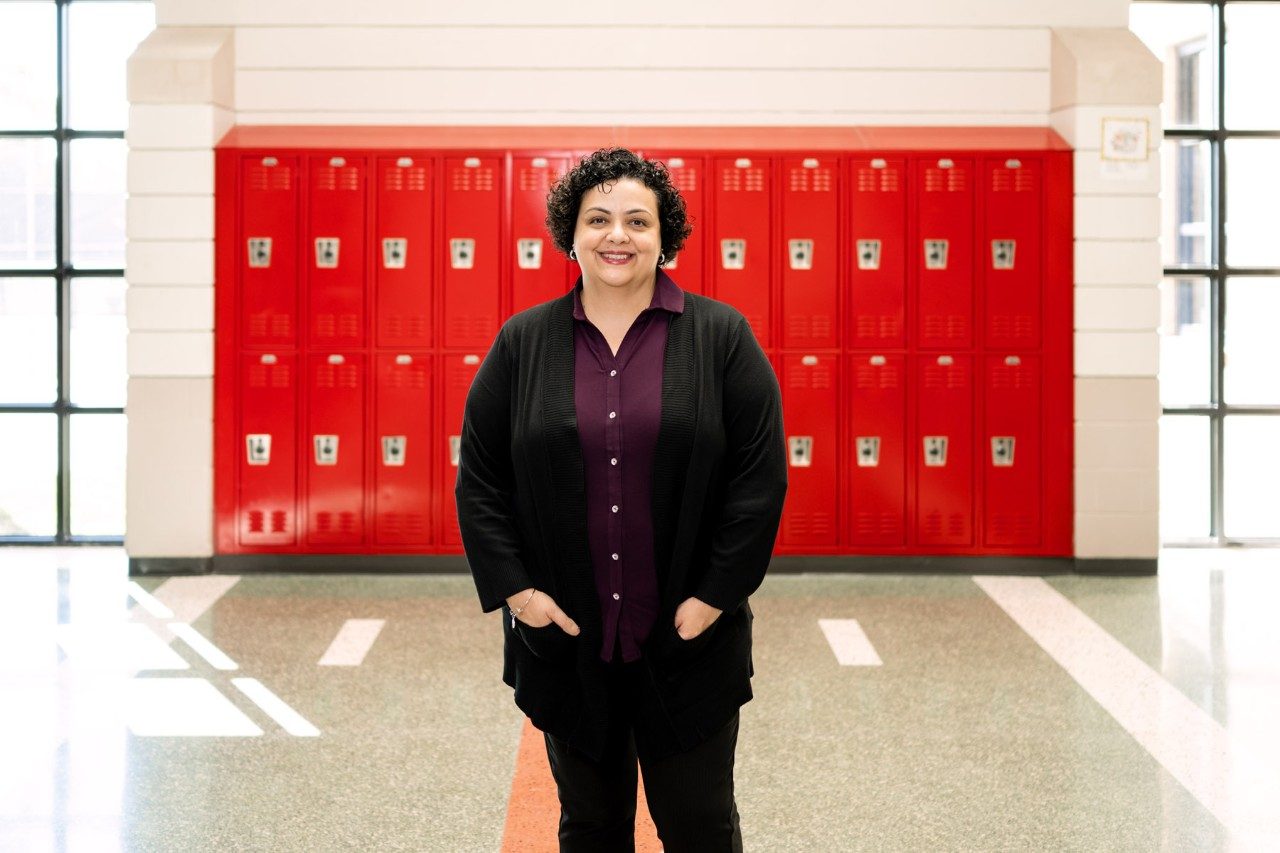 Jeannette Salloum stands in front of high school lockers