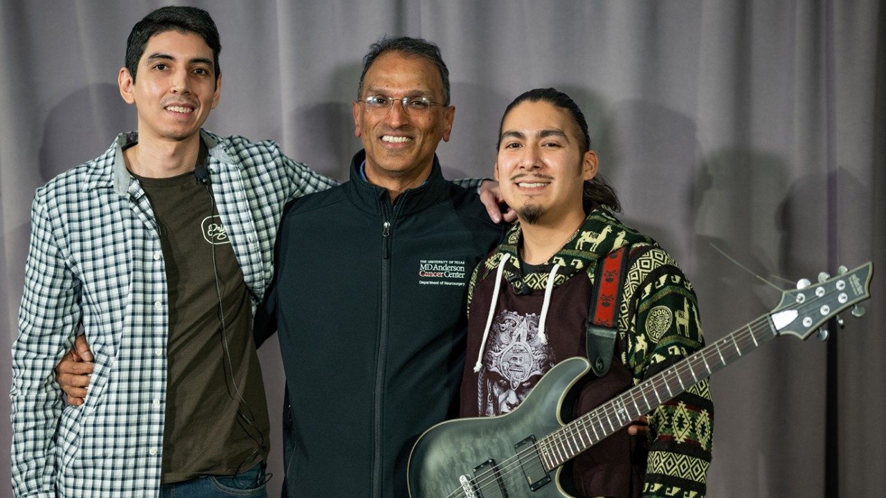 Neurosurgeon Sujit Prabhu, M.D., (center) poses with brain tumor survivors Adrian Rivas (left) and Robert Alvarez. Both musicians played their instruments during awake craniotomies performed by Prabhu to help guide the brain surgeries.