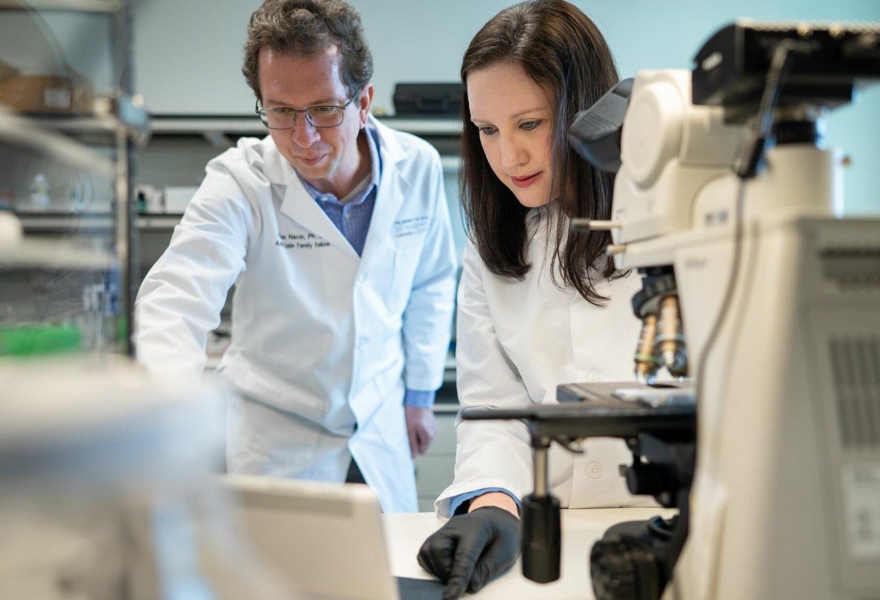 Man and woman wearing white lab coats in a lab
