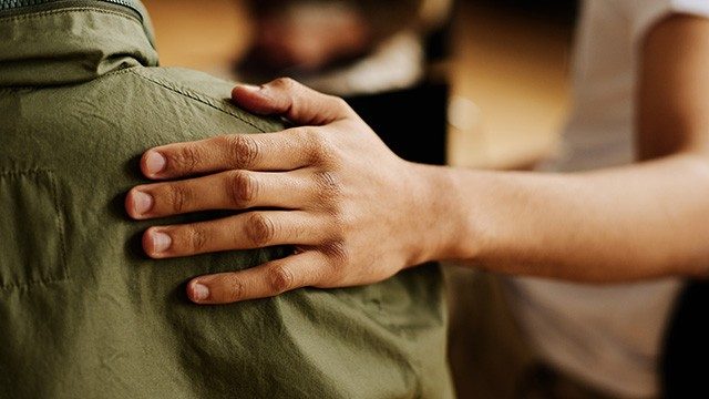 Close-up of someone's hand on another person's shoulder