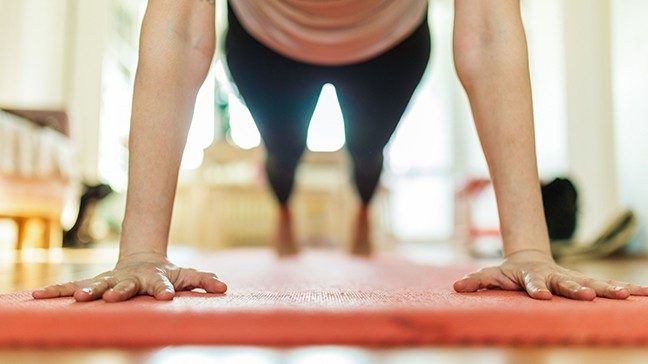 Woman with her palms facing down in a push-up position.