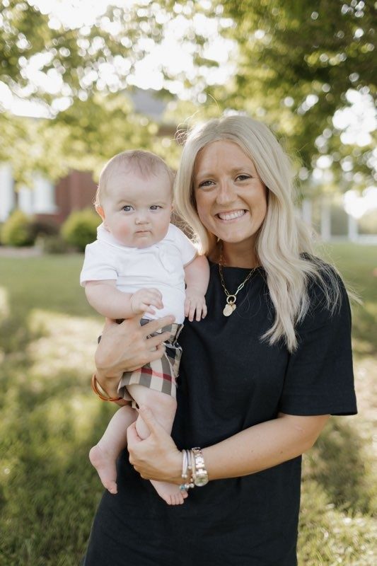 Woman wearing black dress holding a baby