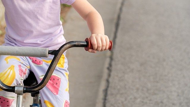 Unidentifiable young girl on a bike 