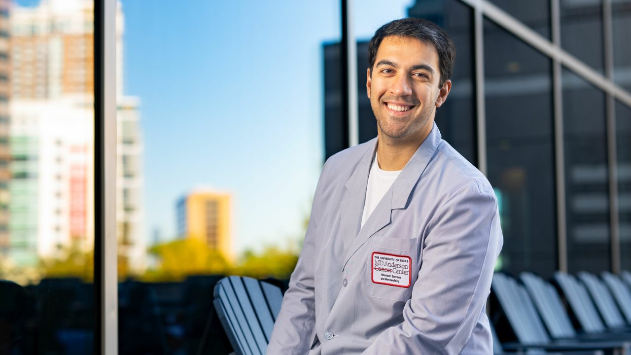 Man wearing a blue blazer with an MD Anderson volunteer services badge 