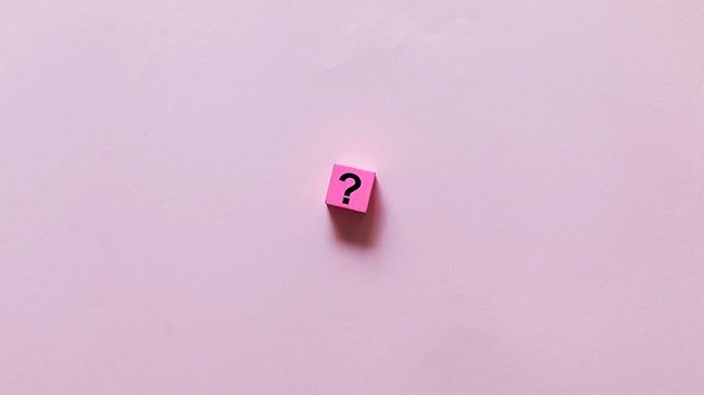 Pink square with a question mark inside of it on a light pink background