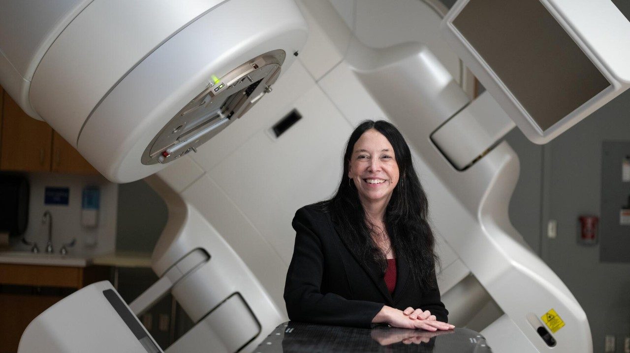 Doctor sits in front of a linear accelerator