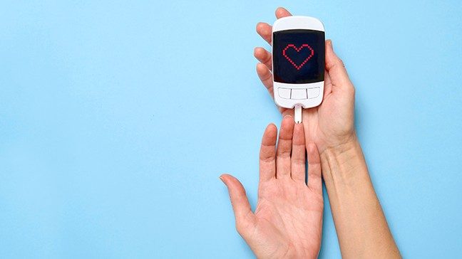 A woman uses a glucometer to check her glucose levels.