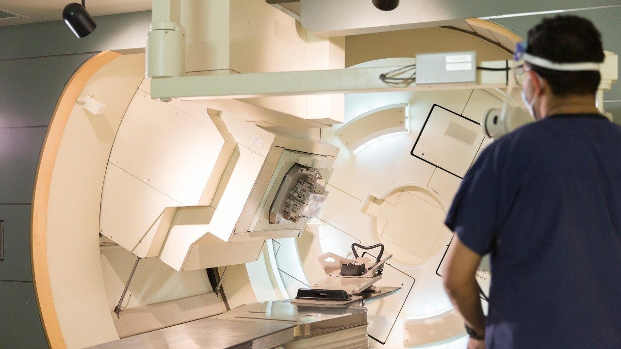 Doctor standing next to a radiation machine