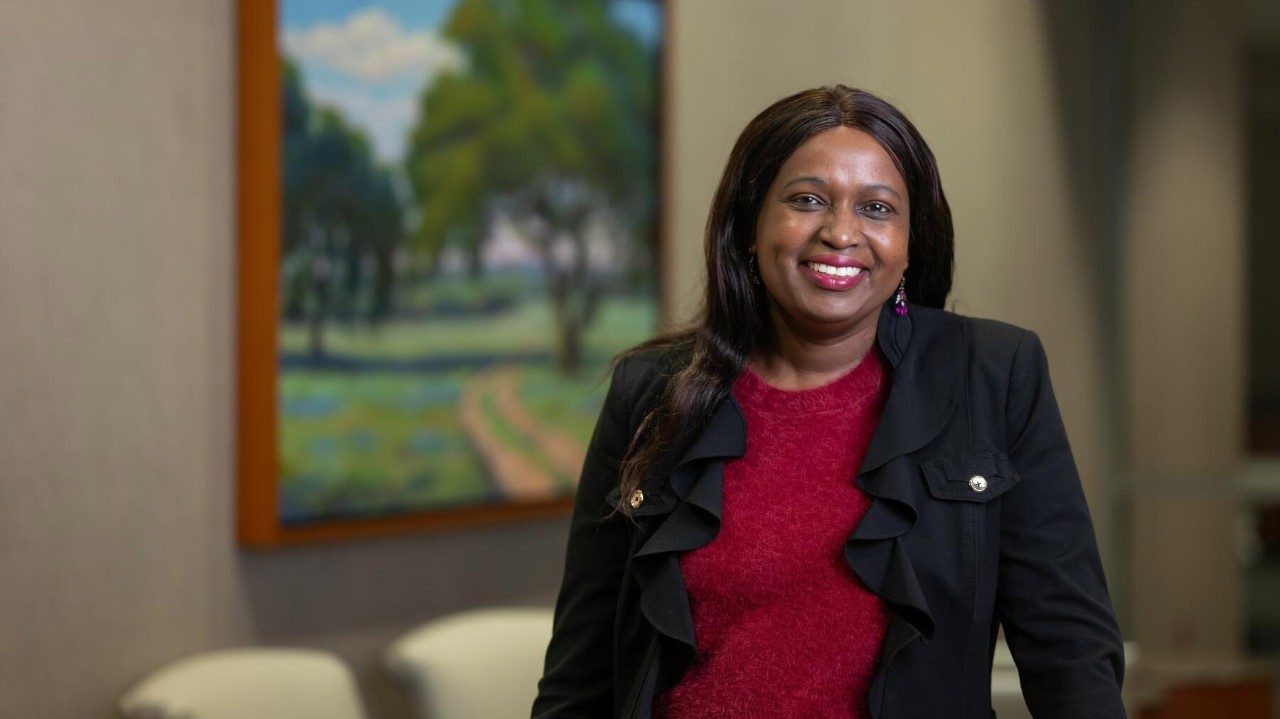 A smiling woman standing in a clinic waiting area