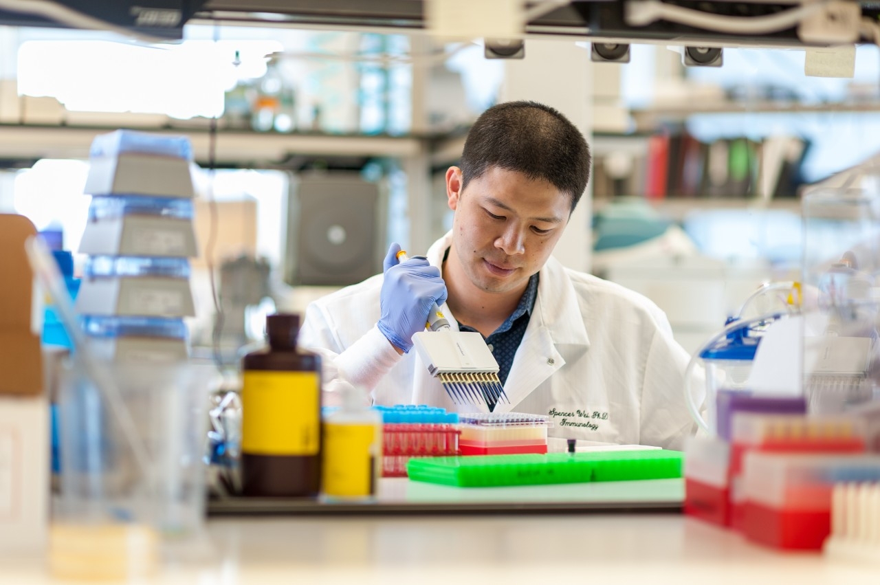 Spencer Wei, Ph.D.. working with pipette in lab