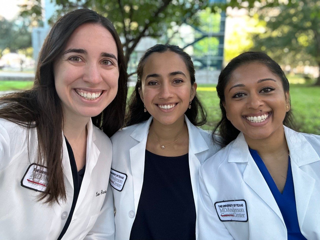 First year Hematology Oncology fellows pose for a selfie while wearing white lab coats with the MD Anderson logo visible