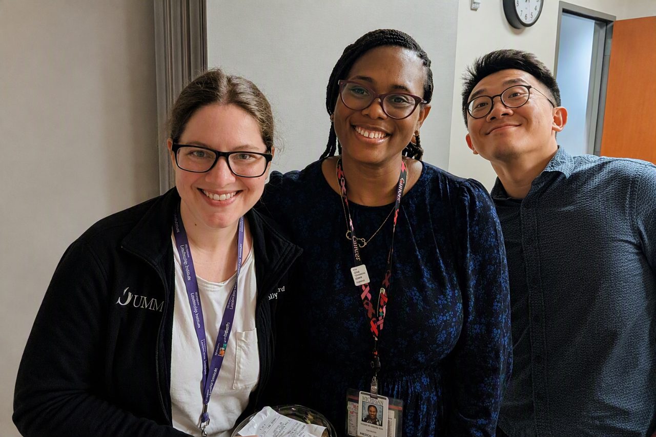 Three fellows smiling in an office