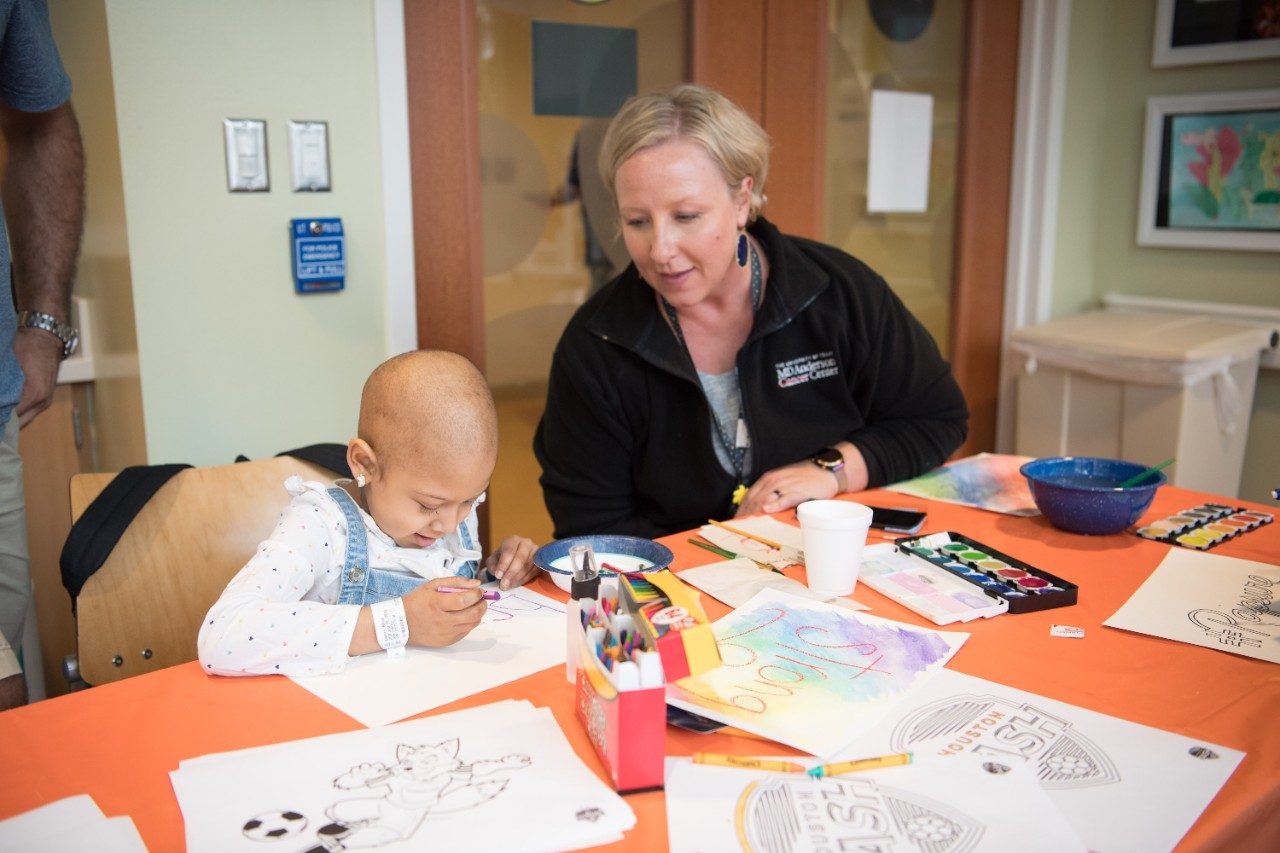 Staff member watches pediatric patient color